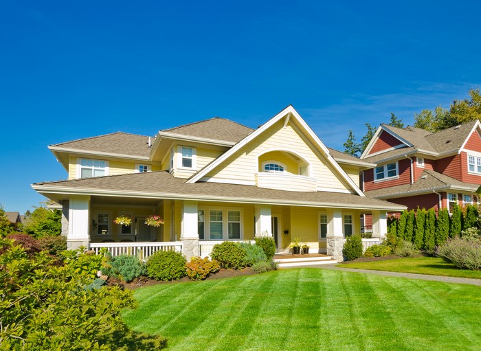 Yellow suburban house with manicured lawn