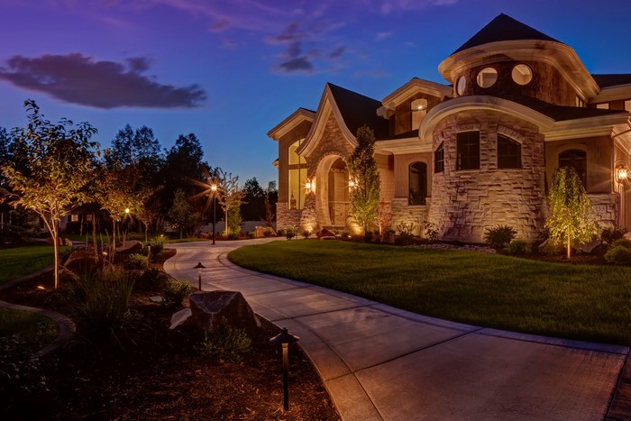 Luxury Mansion Exterior with Landscape Lighting at Dusk