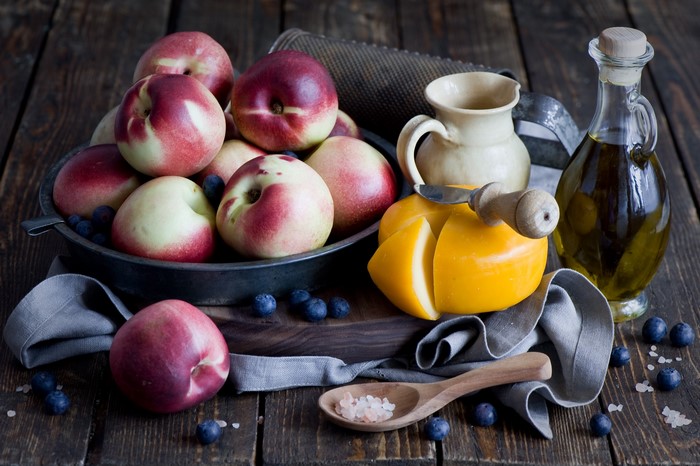 Still life of peaches, cheese, blueberries, and olive oil