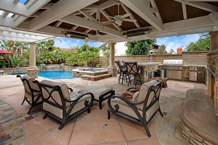 Outdoor patio with pool, spa, and grill area