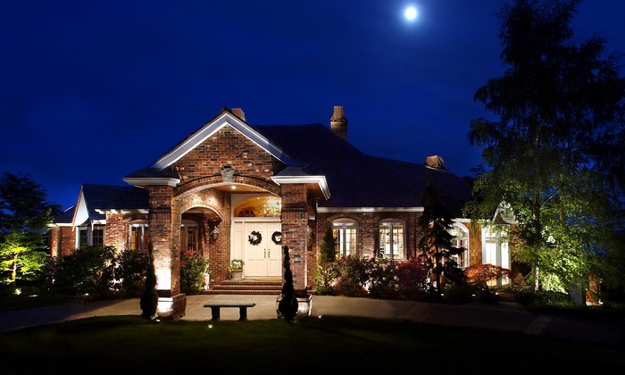 Brick mansion at night with a full moon