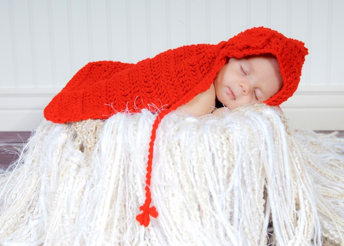 Baby sleeping in a red hooded blanket