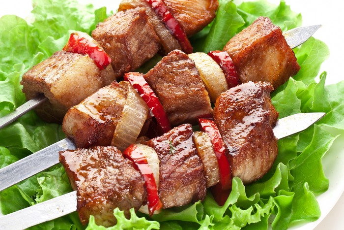 Meat shashlik with vegetables on lettuce