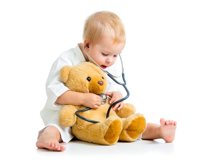 Boy playing doctor with teddy bear