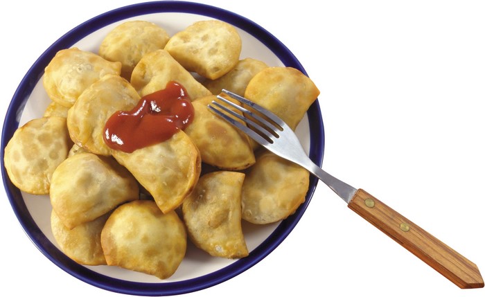 Plate of pierogi with ketchup and fork