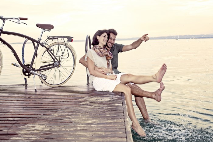 Couple with bicycle on a pier