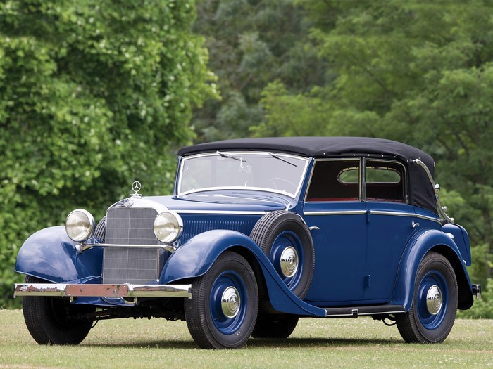 Blue Mercedes-Benz convertible parked on grass with trees