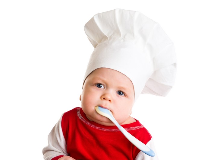 Baby wearing a chef hat with a spoon
