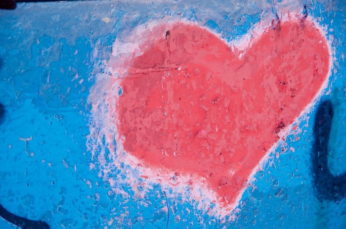 Red heart graffiti on a blue wall