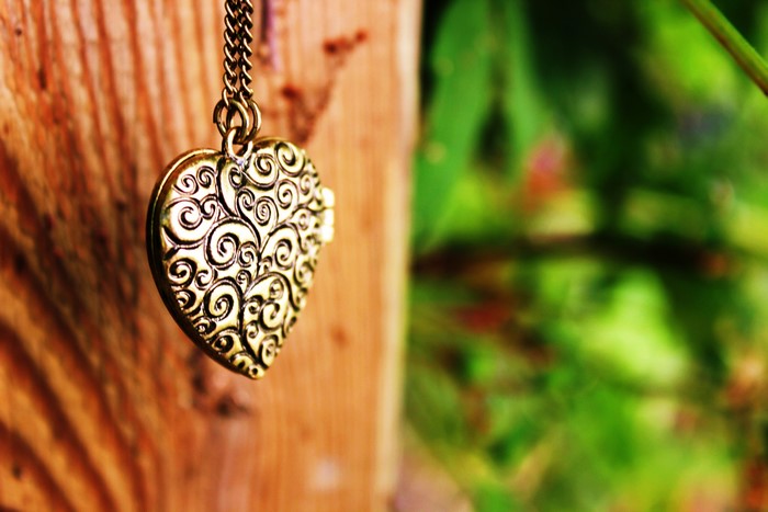 Heart locket necklace on wooden post