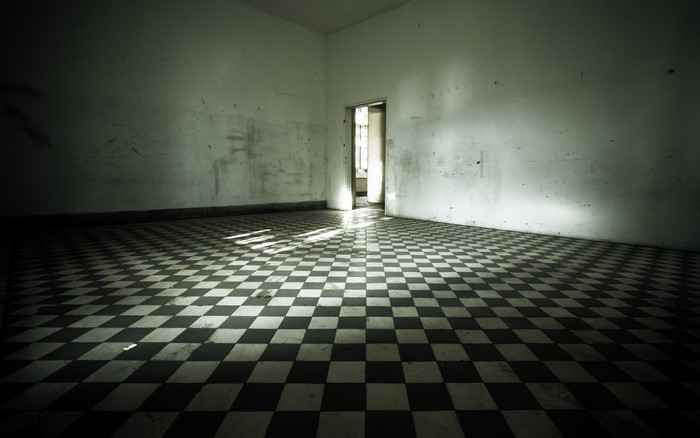 Empty room with checkered floor and doorway