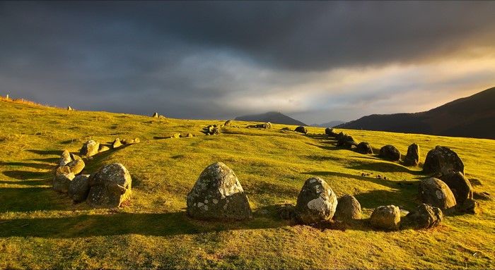 Standing Stones on a Grassy Hill Under a Thunderous Sky