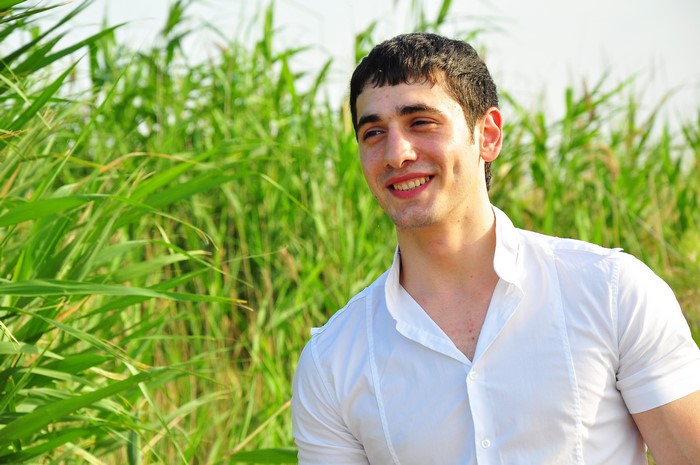 Young man smiling in grass