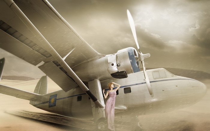 Woman in a pink dress standing by an airplane