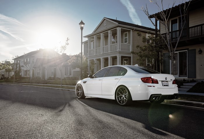 White BMW M5 F10 parked on asphalt street