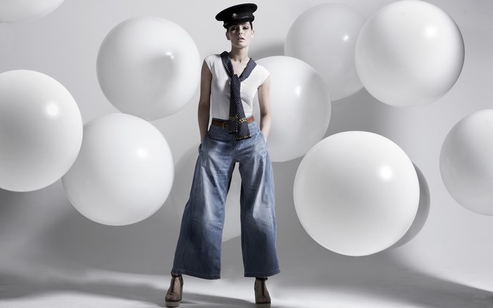 Woman in hat and wide-leg jeans with white balls