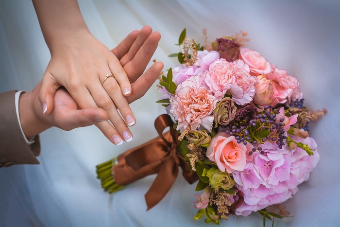 Wedding bouquet and hands with ring