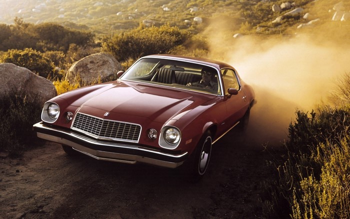 1974 Chevrolet Camaro Sport Coupe driving on dirt road