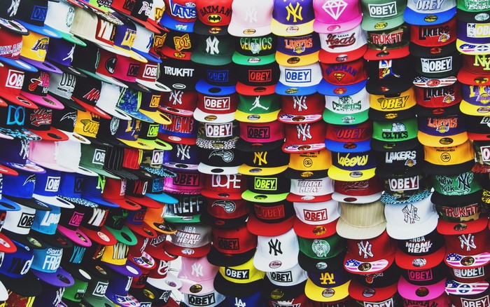 Wall of baseball caps with various logos