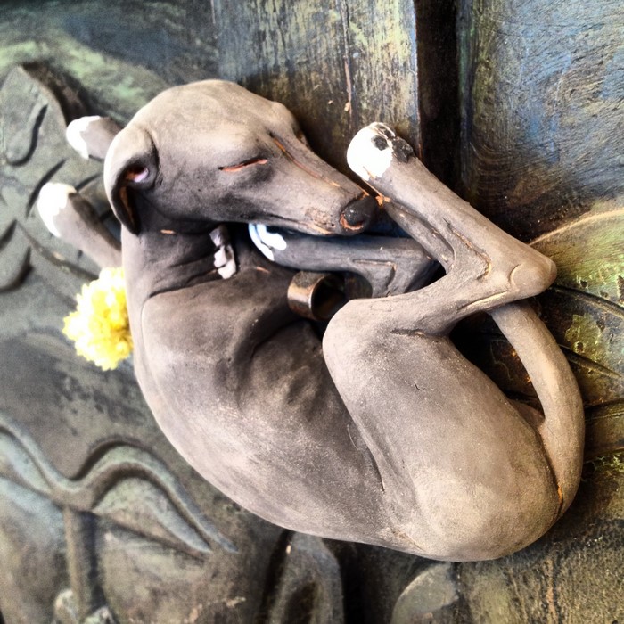 Sculpture of a sleeping sighthound dog