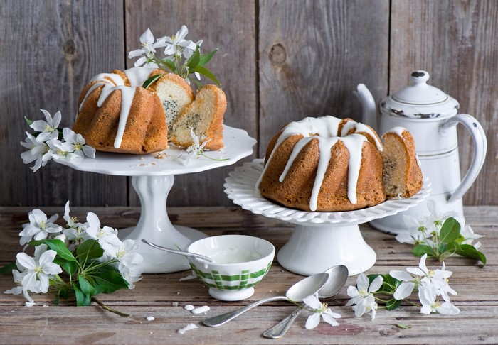 Two bundt cakes with icing and white flowers