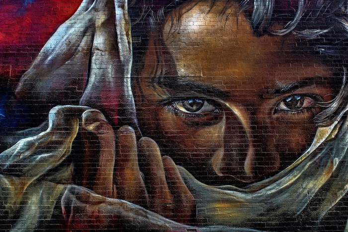 Graffiti of a person's face on a brick wall