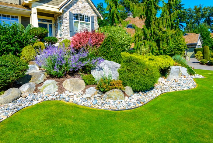 House with manicured lawn and rock garden landscaping