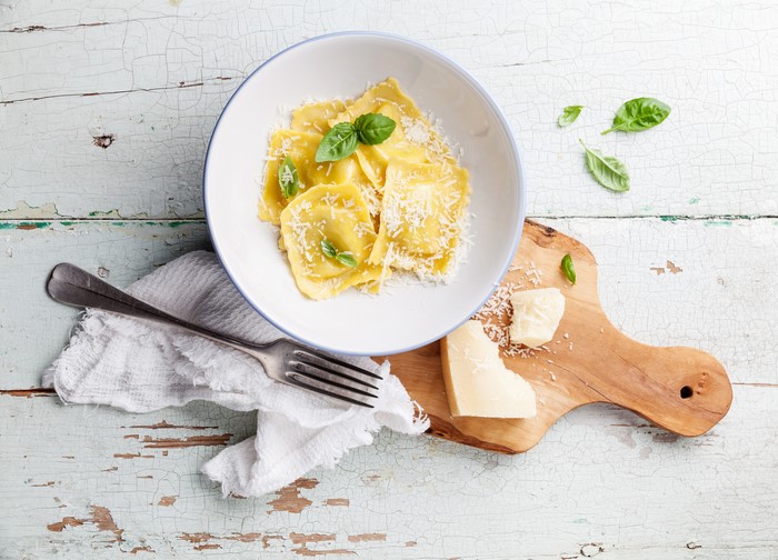 Ravioli with grated cheese and basil on a plate