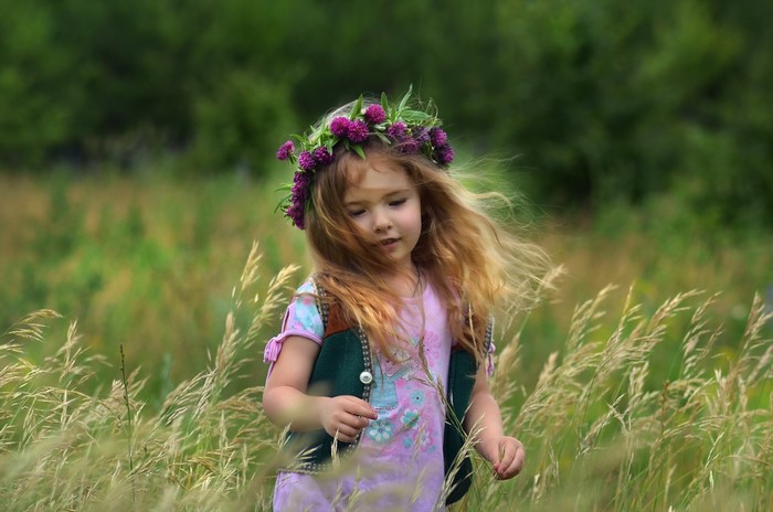 Young girl with flower crown in a grassy field