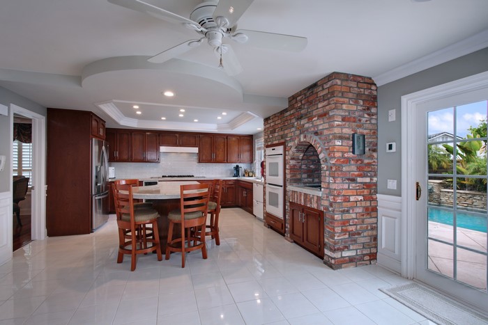 Kitchen with brick fireplace and pool view