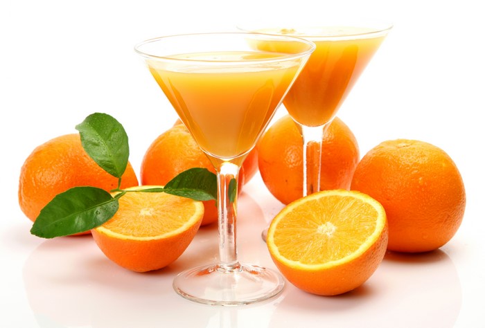 Two glasses of orange juice with oranges