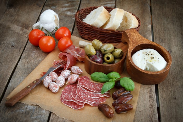 Still-life of Italian antipasto with sausage, cheese, and bread