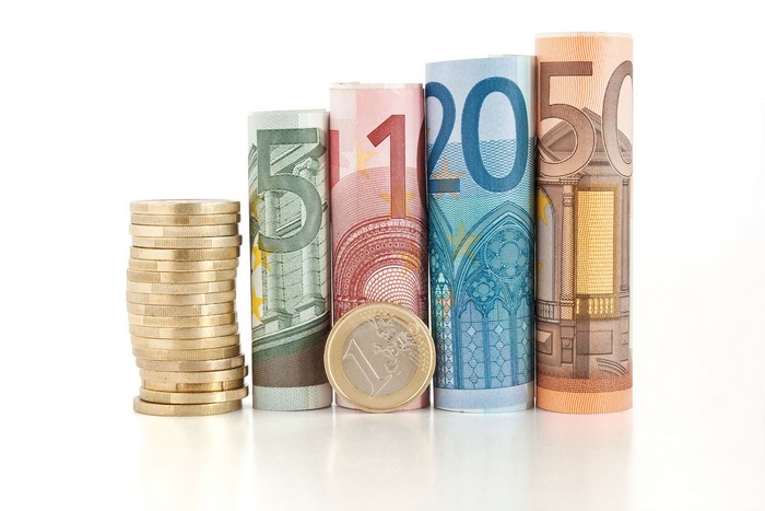 Euro banknotes and coins arranged in ascending order