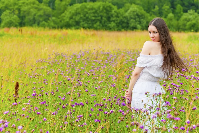 Woman in white dress in a field of flowers
