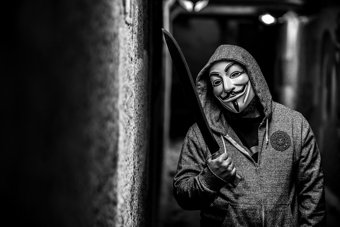 Man in Guy Fawkes mask holding a sword
