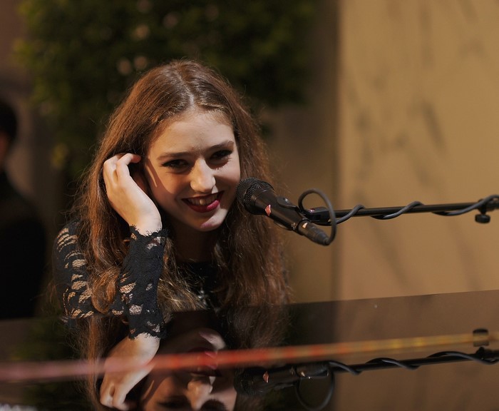 Young girl playing piano with microphone