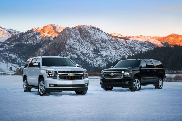 Two Chevrolet Suburbans in a Snowy Mountain Landscape