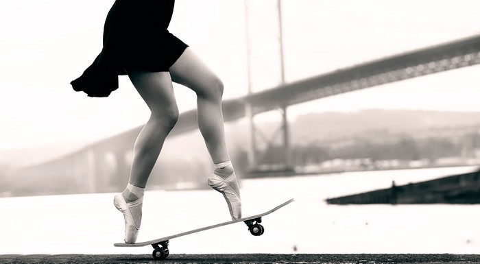 Ballerina on a skateboard in front of a bridge