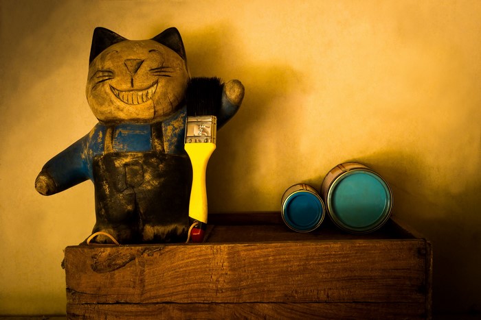 Wooden cat doll with paintbrush and paint cans