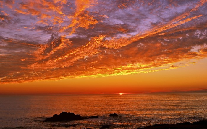 Sunset over the ocean with dramatic clouds