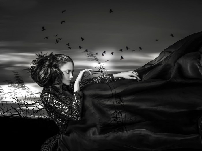 Woman in black dress with birds in the sky