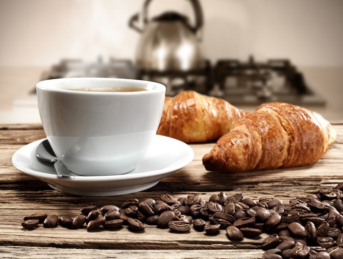 Coffee cup and croissants on a wooden table