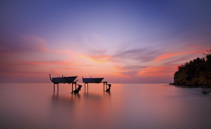 Boats on stilts at sunset over the sea