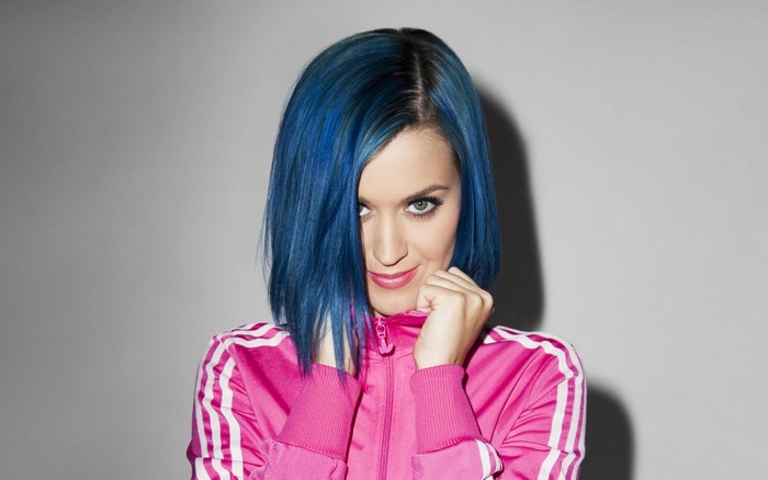 Katy Perry with blue hair wearing a pink jacket