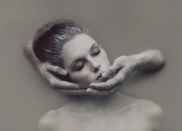 Woman's face held by hands