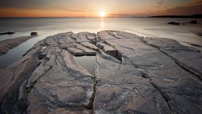 Rocky Shoreline at Sunset with Calm Water