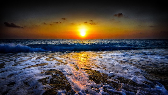 Sunset over the ocean with waves