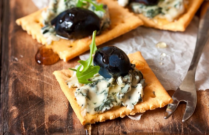 Crackers with blue cheese, grapes, and arugula