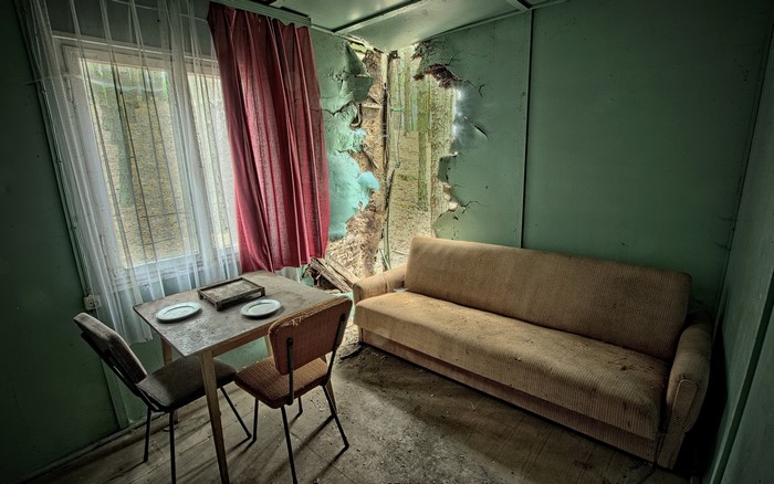 Abandoned room with sofa, table, and chairs
