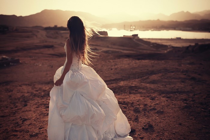 Bride in a white dress in a desert landscape